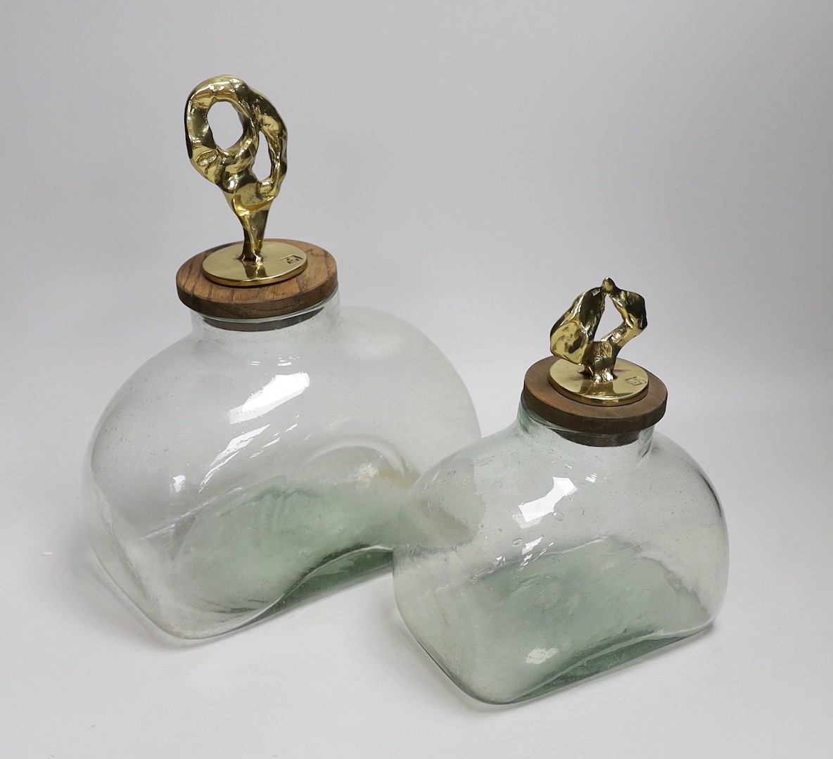 Two graduated large green glass bottle canisters with ornate brass sculptural covers, cars mark ‘dh’